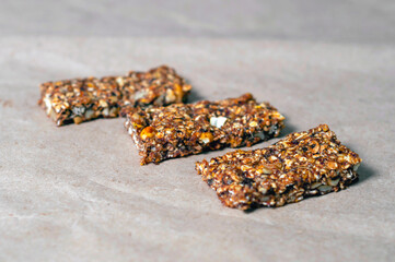 bar with granola, dried fruits and nuts on craft paper.