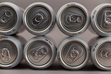 Geometric composition of full tin cans. Cylindrical silver individual beverage containers. Close-up. Selective focus.