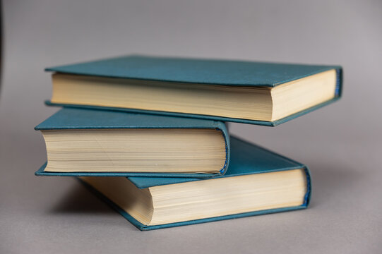 Three in the blue cover opposite the gray background. Hardcover books. Selective focus.