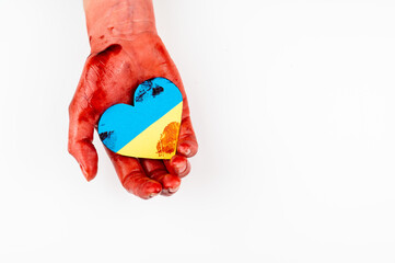 Woman with hands covered in blood holding a heart with the flag of ukraine on a white background. Copy space. 