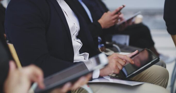 Taking notes on their most efficient devices. Group of diverse and different aged business people using wireless digital technology while listening to seminar workshop presentation in conference