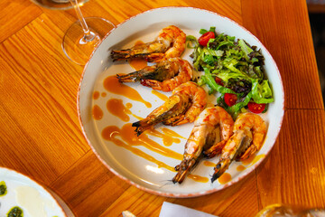 Appetizing fried shrimp in mustard sauce with fresh vegetables
