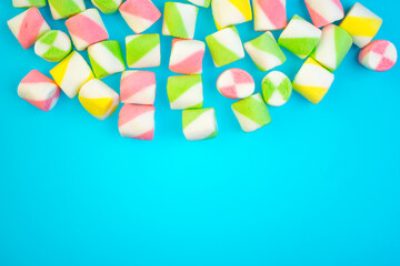 Background or texture of colorful blue and pink marshmallows.Multi-colored marshmallows on a blue background