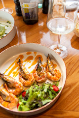 Appetizing fried shrimp in mustard sauce with fresh vegetables