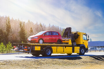 Yellow Flatbed Tow Truck Carrying Red Breakdown Car