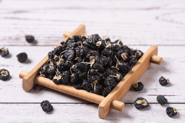 dry black wolfberry or black goji berries on wooden table