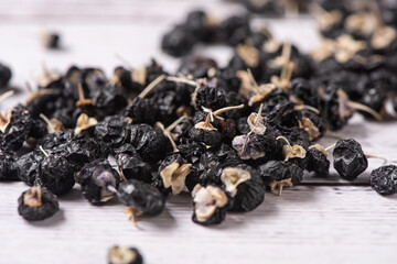 close up of black wolfberry on wooden table