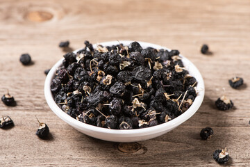 dry black wolfberry or black goji berries on wooden table
