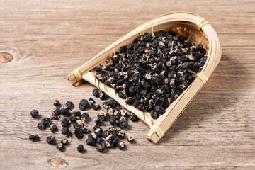 dry black wolfberry or black goji berries on wooden table