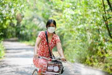 Asian woman riding bicycle in the city park