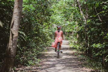 Fototapeta premium Asian woman riding bicycle in the city park