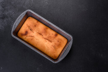 Baked rectangular cupcake with raisins and chocolate on a dark concrete background