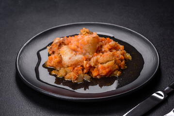 A delicious dish of hake fish in chunks in tomato sauce with spices and herbs