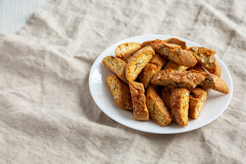 Homemade Italian Cantuccini with Almonds on a White Plate, side view. Crispy Almond Cookies. Copy space.