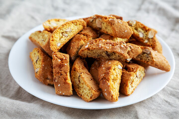 Homemade Italian Cantuccini with Almonds on a White Plate, side view. Crispy Almond Cookies. Close-up.