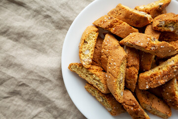Homemade Italian Cantuccini with Almonds on a White Plate, top view. Crispy Almond Cookies. Flat lay, overhead, from above. Copy space.
