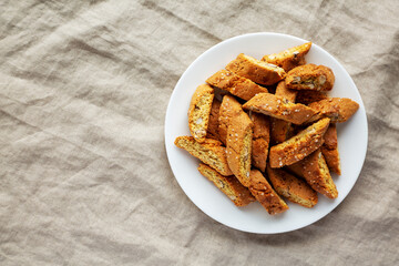 Homemade Italian Cantuccini with Almonds on a White Plate, top view. Crispy Almond Cookies. Flat lay, overhead, from above. Space for text.