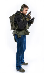 soldier, airsoft player in full gear with a gun. a man in headphones, body armor, with a backpack and a belt. White background.