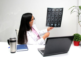 Latina female neurologist doctor with glasses and face mask gives remote consultation by video call...
