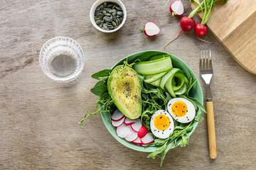 Healthy green salad with avocado and eggs.