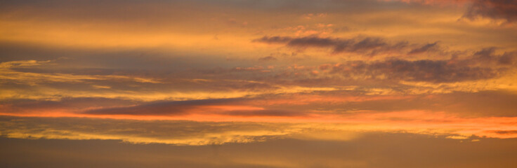Panorama d'un ciel zen avec nuages colorés orange et jaune au coucher du soleil avec espace pour texte