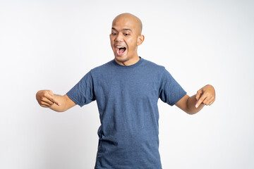 excited bald young man with two fingers pointing down on isolated background