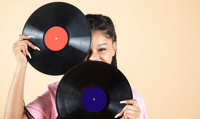 Retro image of afro american woman with vinyl record on beige studio background