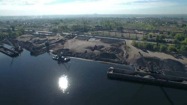 Port crane morning loading of sand and crushed stone on the river in an industrial area. Aerial panorama.