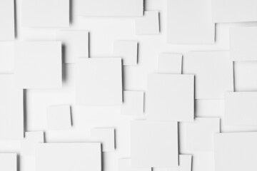 White abstract geometric background with paper squares in bright light with shadows, top view. Simple mosaic pattern in minimalist style.