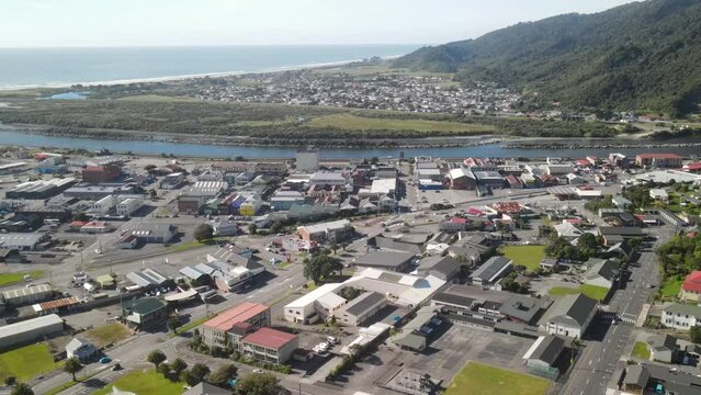 Aerial pull back of Greymouth town centre, Cobden suburb, river and coastal landscape. New Zealand cityscape