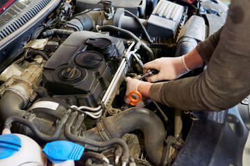 Mechanic changing the glow plugs of a car