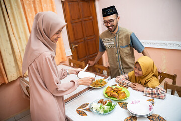 muslim mother serving some food for family dinner during ramadan kareem