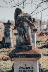 Damaged gravestone, beheaded stone angel sculpture at abandoned ancient cemetery. Forgotten...
