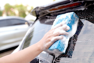 This man is washing the car and cleaning the car.