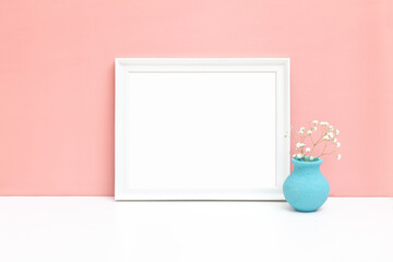 Fototapeta na wymiar White horizontal wooden frame mockup with small vase and white flower