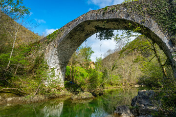Fototapeta na wymiar Roman bridge on the path between the Tornin to the Olla de San Vicente, near Cangas de Onis. Asturias. Spain