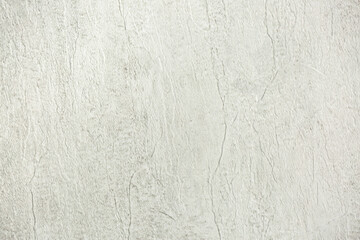 Light background of decorative plaster with abstract spots. Unusual texture of white or gray wall with beautiful patterns, creative surface background. Finishing coating for building cladding.