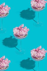 Spring Japanese minimal concept. Pattern made of a unique coupe of glasses with cherry flowers with...