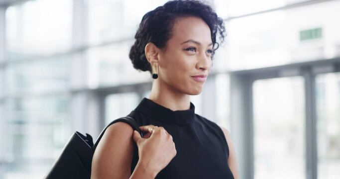 Rock out with your ambition out. 4k video footage of a young businesswoman showing a rock n roll sign while walking through a modern office.