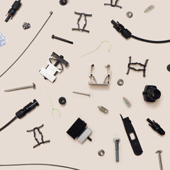 Various components for solar panels minimal concept. Pattern made of male female connectors, cable ties, tool kits, alu profile, mid and end clams, different screws and bolts. Flat lay gray background