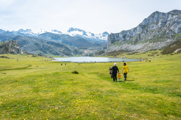 Fototapeta na wymiar Grandmother, mother and son sightseeing at Lake Ercina in the Lakes of Covadonga. Asturias. Spain