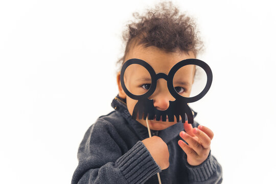 Funny kid with fake mustache, isolated white background. High quality photo