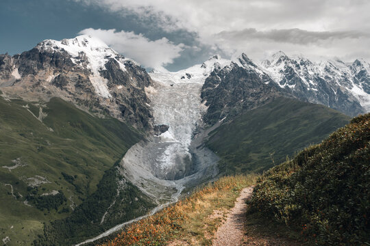 An amazing view on the Shkhara Glacier in the Greater Caucasus Mountain Range in Georgia, Svaneti Region, Ushguli. Snow-capped mountains. Mount Shkhara. Melting Glacier. Climate change. Ice, cold.