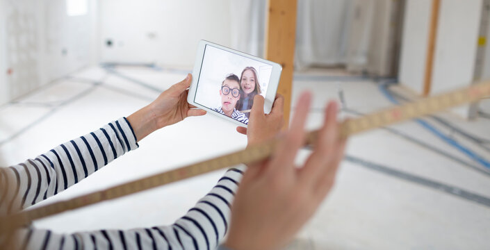 Brother and sister are on the construction site of their new room loft apartment and take selfie with a tablet