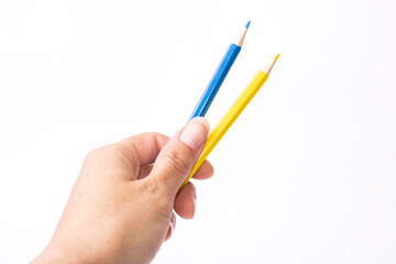Blue and yellow pencils in hand on white background