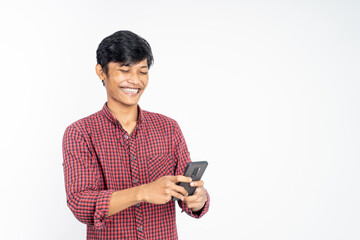 happy asian young man looking at the screen of a mobile phone on isolated background