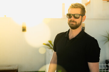 Hipster handsome male model with beard wearing black polo shirt with space for your logo or design...