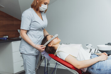 dentist puts inhalation sedative mask on his patient. - obrazy, fototapety, plakaty