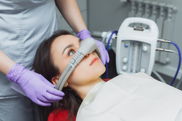 dentist puts inhalation sedative mask on his patient.