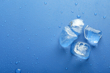 Ice forms on wet blue background, space for text